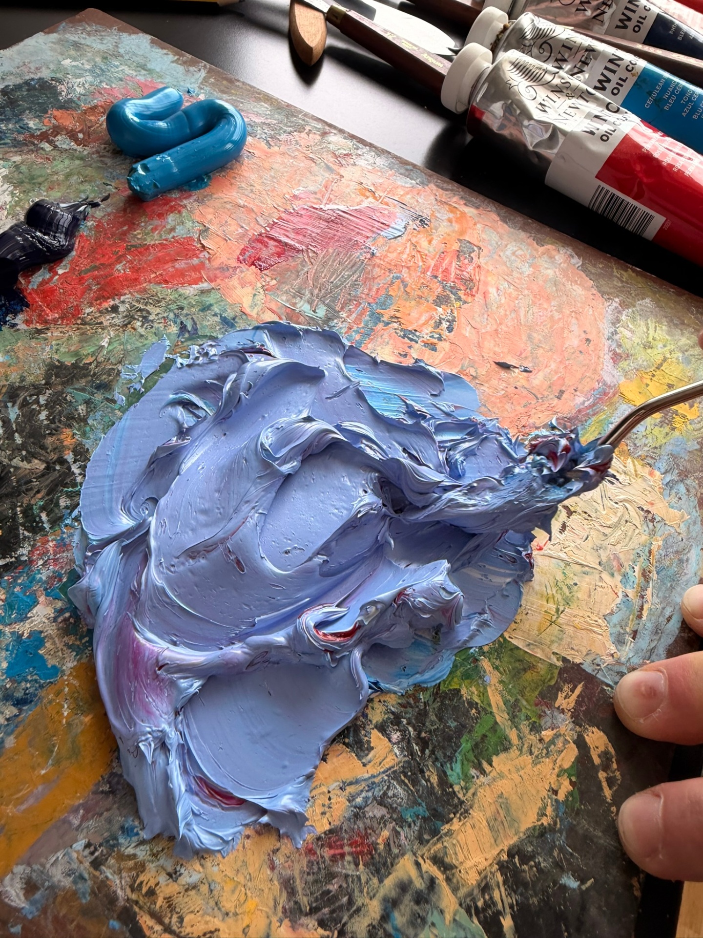 Lavender oil paint mixed on the palette with a palette knife