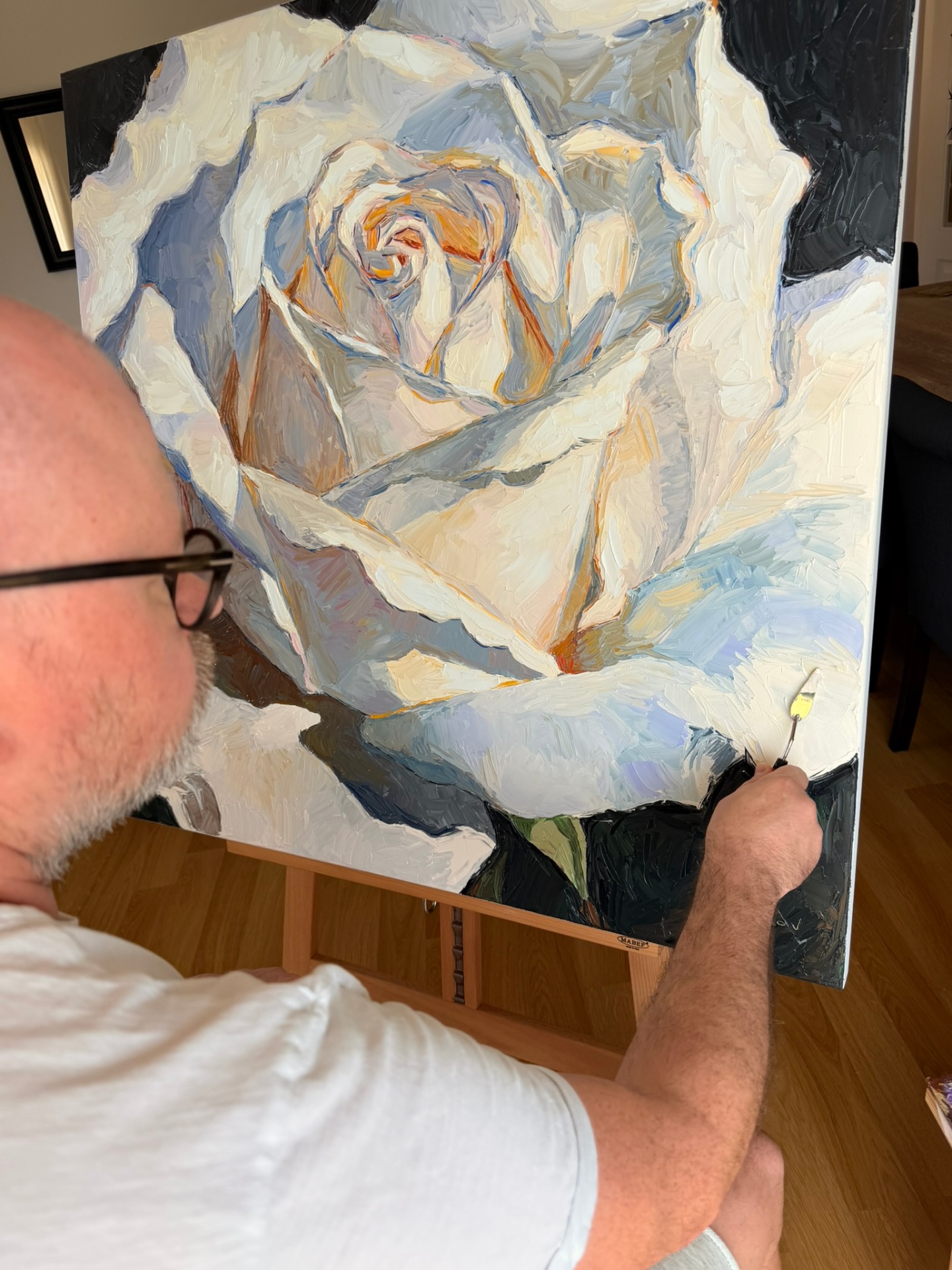 Evgeny Maximov refining the White Rose with a palette knife on the easel